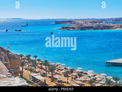 The comfortable sand beach with sunshades and palm trees, Sharm El Maya district, Sharm El Sheikh, Sinai, Egypt. Stock Photo
