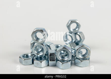 Chrome caps on a white table. Accessories for mounting steel structures on a workshop table. White background. Stock Photo
