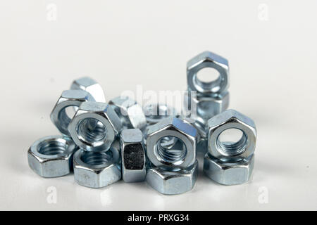 Chrome caps on a white table. Accessories for mounting steel structures on a workshop table. White background. Stock Photo