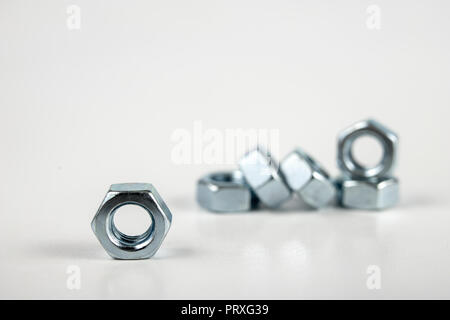 Chrome caps on a white table. Accessories for mounting steel structures on a workshop table. White background. Stock Photo