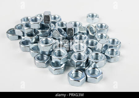 Chrome caps on a white table. Accessories for mounting steel structures on a workshop table. White background. Stock Photo