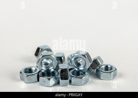 Chrome caps on a white table. Accessories for mounting steel structures on a workshop table. White background. Stock Photo