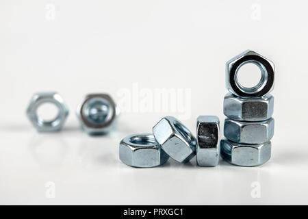 Chrome caps on a white table. Accessories for mounting steel structures on a workshop table. White background. Stock Photo
