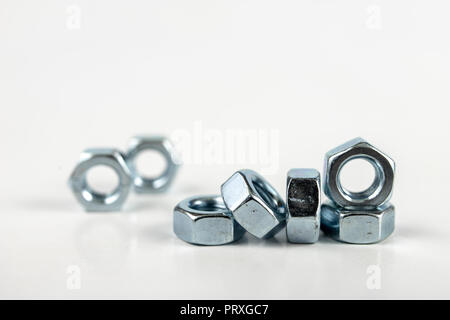 Chrome caps on a white table. Accessories for mounting steel structures on a workshop table. White background. Stock Photo