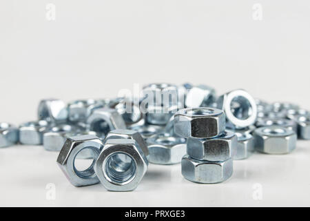 Chrome caps on a white table. Accessories for mounting steel structures on a workshop table. White background. Stock Photo