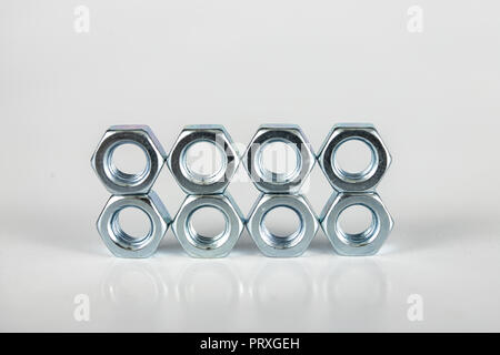 Chrome caps on a white table. Accessories for mounting steel structures on a workshop table. White background. Stock Photo