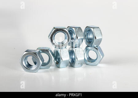 Chrome caps on a white table. Accessories for mounting steel structures on a workshop table. White background. Stock Photo