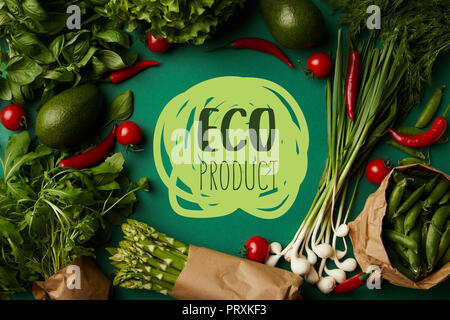 top view of round frame made of various ripe vegetables on green surface with "eco product" lettering Stock Photo