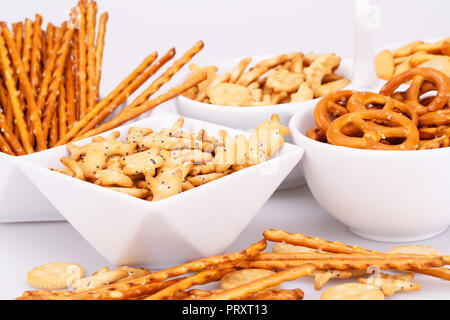 Different salted crackers in bowls on white background. Stock Photo
