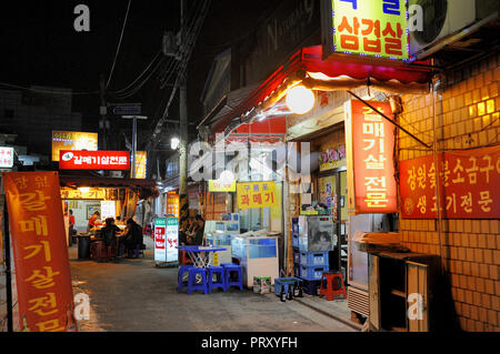 SEOUL,SOUTH KOREA-NOVEMBER 09,2015: Small outdoor restaurant in narrow alleyway in the Haebangchon district. Stock Photo