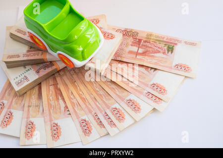 bank and russian money. Car expenses concept.Toy car on the background of banknotes.Model of car against background of monetary denominations of 5000 rubles of Russia. Concept of car loans, leasing, car insurance. Stock Photo