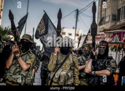 Military officers are seen standing holding weapons during the march. Members of the Palestinian Al-Quds Brigades, the military wing of the Islamic Jihad group march in the streets of Gaza city with their weapons to show loyalty for the Iranian-backed Palestinian movement's newly elected leader Ziad al-Nakhalah. Stock Photo