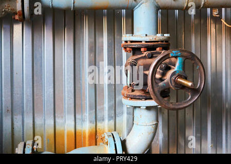 Old valves on the cold water pipeline. Industrial background. Stock Photo