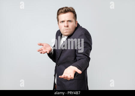 Confused angry young elegant man gestures in bewilderment, expresses negative emotions. Stock Photo