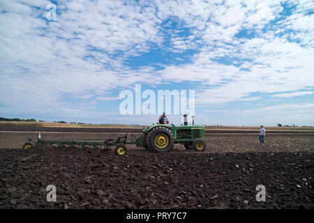 1966 John Deere tractor pulling a 7-bottom plow in an antique tractor demonstration at family farm near Hebron, Illinois. Stock Photo