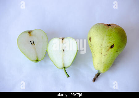 Two pears on white background. One of them is cut in half. Stock Photo