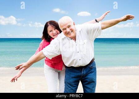 Portrait Of A Happy Senior Couple Having Fun At Beach Stock Photo