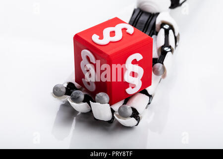 Robotic Hand Holding Red Cubic Block With Paragraph Symbol On Gray Background Stock Photo