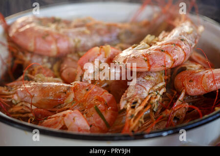 Large shrimps cooked on a grill lie in a saucepan close up Stock Photo