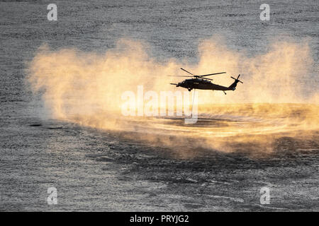 Up close shot of helicopter performing training rescue operation over the columbia river at sunset. Stock Photo