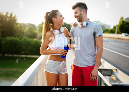 Couple jogging outdoors in the nature and smiling Stock Photo