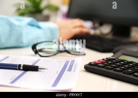 Picture of man is typing on keyboard. Picture of application form, pen, calculator and glasses. Stock Photo
