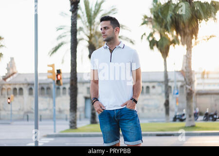 Young man standing in the street with hands in pockets Stock Photo