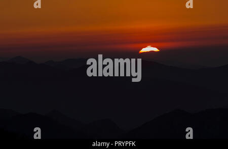 Spain, Cantabria, setting sun behind mountains Stock Photo