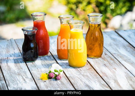 Glass bottles of various fruit juices Stock Photo
