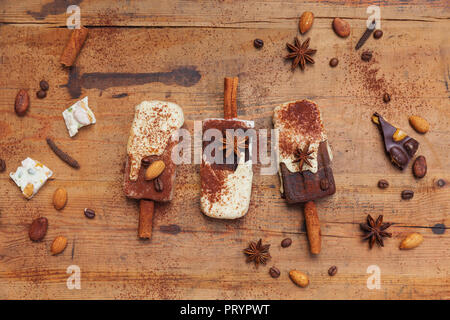 Homemade espresso and white chocolate ice lollies with winter spices on wooden background Stock Photo