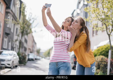 Girlfriends taking selfie in the city Stock Photo