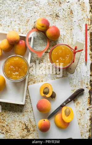 two glasses of apricot juice and apricots with leaves isolated on white ...