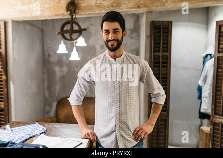 Portrait of smiling man wearing shirt in menswear shop Stock Photo