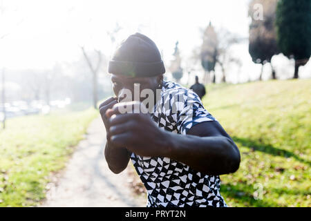 Young man exercising to box in park Stock Photo