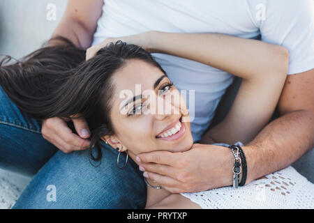 Happy young woman lying on lap of her boyfriend, portrait Stock Photo