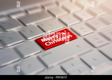 Merry Christmas button on the computer keyboard. red button with the inscription merry Christmas gray silver key board. Stock Photo