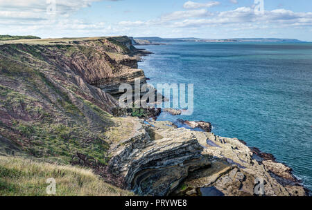 A landscape taken from the top of Filey Brigg, East Yorkshire. Looking down rocky cliffs  on the Northern side towards Scarborough in the distance. Stock Photo