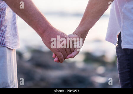 concept of vacation, tourism, travel and people - happy senior couple holding hands. Moment of relaxation and serenity with ethernal foreverness love  Stock Photo