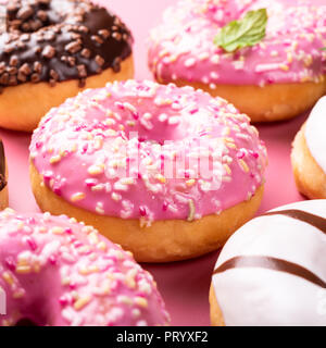 Colorful donuts on rose background Stock Photo