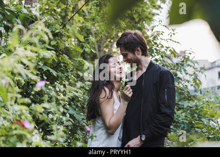 Happy young couple standing in shrubbery Stock Photo