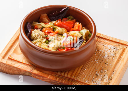 Grilled vegetable salad - cooked on coal and sauteed in butter ghee with onions and coriander. Served in a clay pot on top of a wooden board. Stock Photo