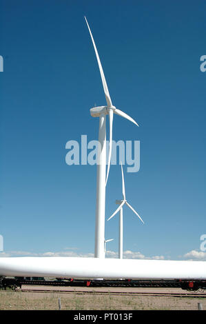 Wind turbins with a long blade in the foreground about to be installed on the next turbin Stock Photo