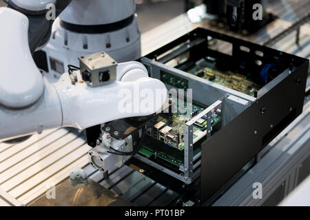 Robotic arm installing a computer chip in factory. Industrial and factory with machine technology 4.0 concept. Stock Photo