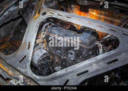 Engine of fully burned car in the forest in summer, accident background Stock Photo