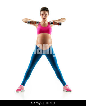 Sporty pregnant woman doing exercises with dumbbells isolated on white background. Concept of healthy life Stock Photo