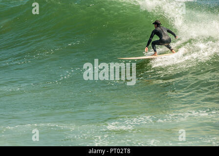 Surfer riding a large point break wave at Sunset Point in Pacific Palisades, Los Angeles County, California. (USA) Stock Photo