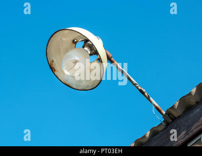 Old street lamp on the roof of the house against the sky Stock Photo