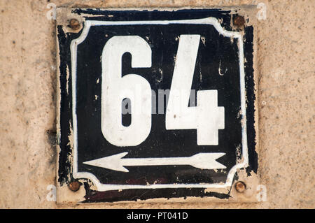Weathered grunge square metal enameled plate of number of street address with number 64 closeup Stock Photo