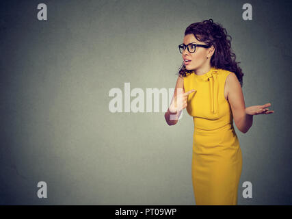 Young elegant woman in yellow dress looking angry while pointing at herself in misunderstanding and looking away Stock Photo