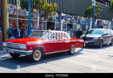 A. classic red Chevrolet Impala cruising on Jefferson Street in San Francisco Stock Photo
